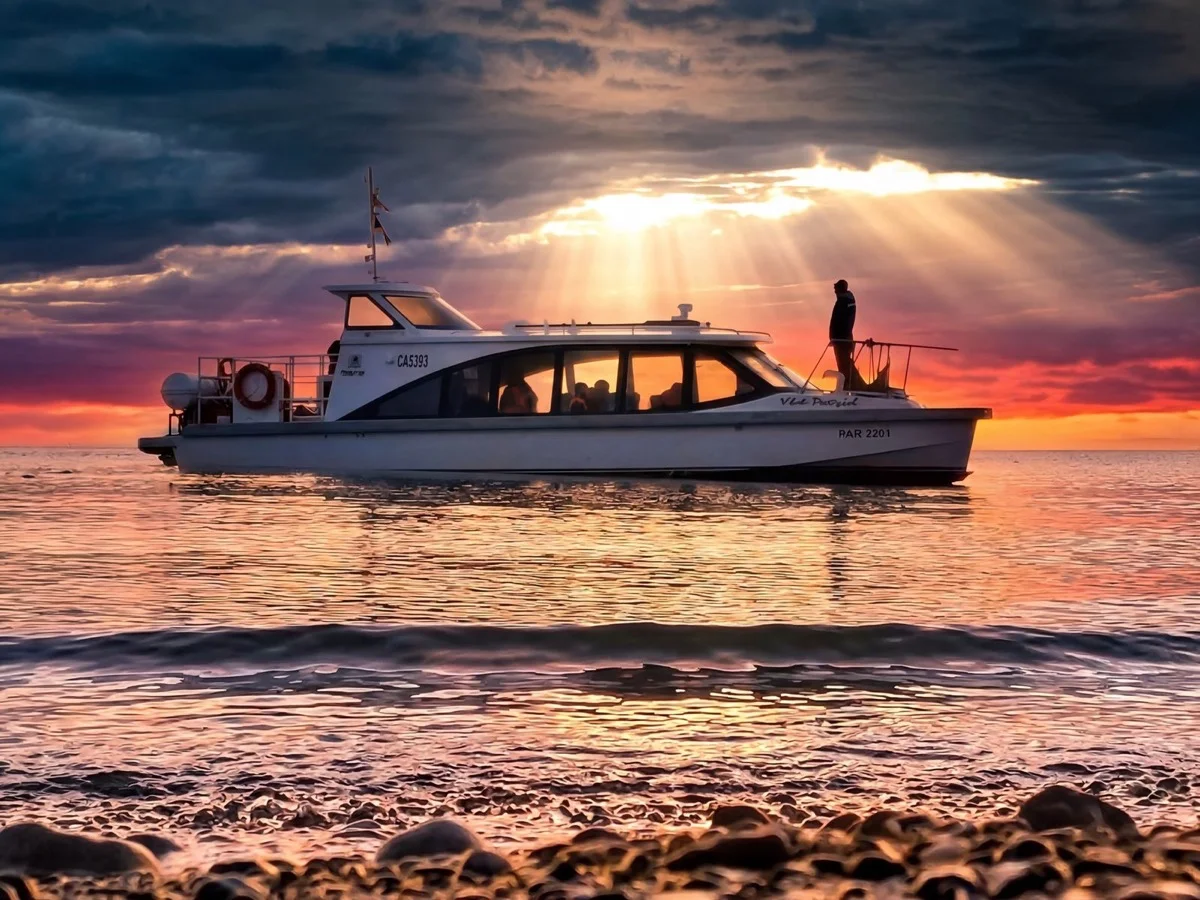 Lancha de KAF zarpando desde Bahía Agua Fresca al atardecer